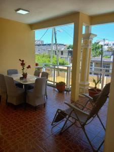 a dining room with a table and chairs and a balcony at Spacious house in Grand Baie with shared pool in Grand Baie