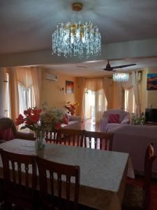 a living room with a table and a chandelier at Spacious house in Grand Baie with shared pool in Grand Baie +20 photos