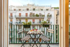 una mesa y sillas en un balcón con un edificio en Quinto Stabile Rooms&Suite, en Palermo
