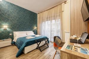 Un dormitorio con una cama y un escritorio con una computadora portátil. en Quinto Stabile Rooms&Suite, en Palermo