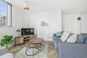 a living room with a blue couch and a table at Spacious & Modern 2BED Apartment in Birmingham in Birmingham +26 photos