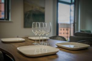 a wooden table with wine glasses and plates on it at Spacious & Modern 2BED Apartment in Birmingham in Birmingham