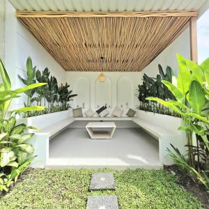 Una zona de estar en un jardín con plantas. en 3 Bedroom Private Pool Villa in Mengwi Kapal, en Kapal