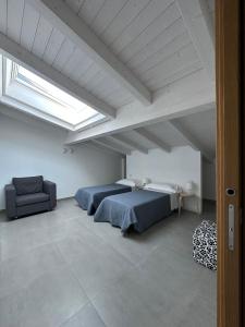 a bedroom with two beds and a couch and a skylight at AGRO Sicily in Mascali +90 photos