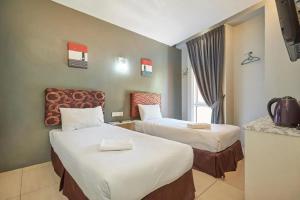 科塔达曼萨拉Swing & Pillows - Kota Damansara的一间有两张床和一台电视的酒店房间