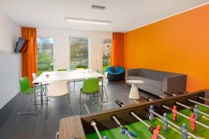 a room with a ping pong table and a couch at Jugendhaus Klipper Norderney in Norderney