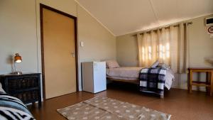 a room with a refrigerator and a bed in it at Jagerskraal Guest Farm in Laingsburg