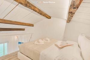 een witte slaapkamer met een bed op zolder bij Casa al Quarto, Terre Marine in Fezzano