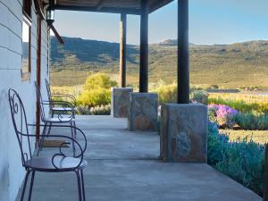 two chairs sitting on a porch with mountains in the background at Jagerskraal Guest Farm in Laingsburg +24 photos