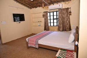 een slaapkamer met een bed en een raam bij Gramya Resort in Alwar +23 foto's