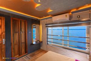 een kamer met een raam met uitzicht op de oceaan bij Karimeen Boathouse in Alleppey