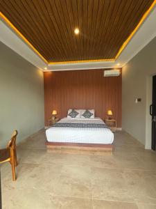 ein Schlafzimmer mit einem großen Bett und einer Holzdecke in der Unterkunft Adiuma Cottage Ubud in Ubud