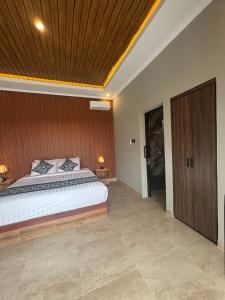 ein Schlafzimmer mit einem großen Bett und einer Holzdecke in der Unterkunft Adiuma Cottage Ubud in Ubud