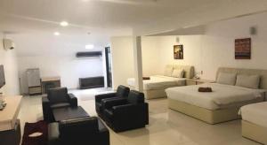 a hotel room with a bed and a couch and chairs at Peach Hill Hotel & Cafe in Kampong Sungai Rinting