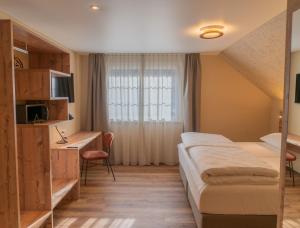 a hotel room with a bed and a desk at Gasthof zum Reh - Self Check-in 