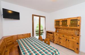 ein Schlafzimmer mit einem Tisch, einem Schrank und einem Fenster in der Unterkunft Casa Luisella in Pieve Di Ledro
