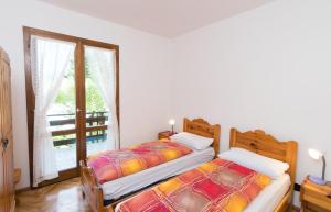 two twin beds in a room with a window at Casa Luisella in Pieve Di Ledro