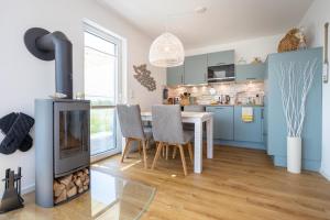 a kitchen with a fireplace and a table and chairs at NordseeResort Tossens - Seaside Corner in Tossenserdeich