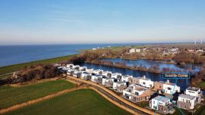 an aerial view of a large apartment complex next to the water at NordseeResort Tossens - Seaside Corner in Tossenserdeich