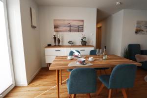 Una cocina y un comedor con mesa y sillas de madera. en Küste33-15 - Strandnest, en Tossenserdeich