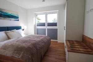 Un dormitorio con una cama grande y una ventana. en Küste33-15 - Strandnest, en Tossenserdeich