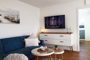 Una sala de estar con un sofá azul y una mesa. en Küste33-15 - Strandnest, en Tossenserdeich