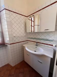 ein weißes Badezimmer mit Waschbecken und Spiegel in der Unterkunft Il nido sul Duomo in Prato