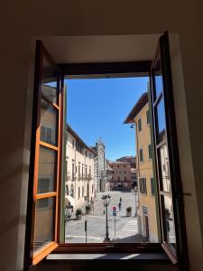 ein offenes Fenster mit Blick auf eine Stadtstraße in der Unterkunft Il nido sul Duomo in Prato
