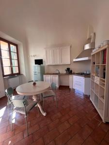 eine Küche mit einem Tisch und Stühlen sowie eine Küche mit weißen Schränken in der Unterkunft Il nido sul Duomo in Prato