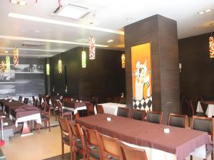 a dining room with tables and chairs and a painting on the wall at MB Hotel in Tawau