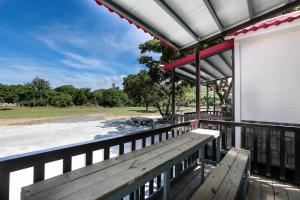 a porch with a bench and a view of a field at Kenting Dream House in Kenting