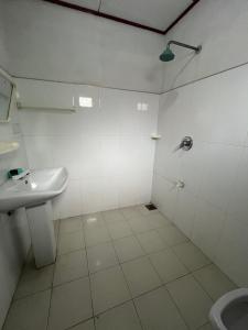 une salle de bain blanche avec un lavabo et des toilettes dans l'établissement Vidara Guest House, à Weligama