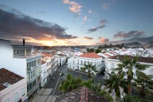 uitzicht op een stad met gebouwen en palmbomen bij Casa das Palmeiras Charming House - Azores 1901 in Ponta Delgada