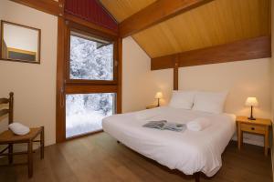 una camera da letto con un grande letto bianco e una finestra di Chalet Résidence Chantey Mourry 67 - Happy Rentals a Chamonix-Mont-Blanc
