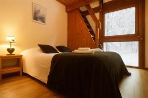 una camera da letto con un letto in una stanza con una finestra di Chalet Résidence Chantey Mourry 67 - Happy Rentals a Chamonix-Mont-Blanc