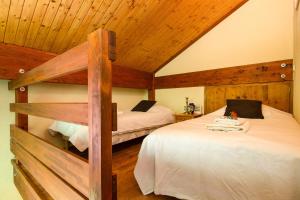 due letti in una stanza con soffitti in legno di Chalet Résidence Chantey Mourry 67 - Happy Rentals a Chamonix-Mont-Blanc
