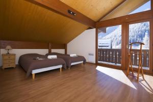 una camera da letto con due letti e un balcone di Chalet Résidence Chantey Mourry 67 - Happy Rentals a Chamonix-Mont-Blanc Altre 15 foto