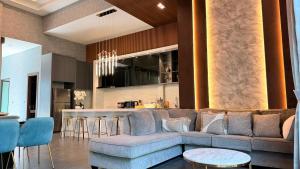 a living room with a couch and a kitchen at PNT VILLA PATTAYa in Nong Prue