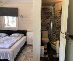 a bedroom with a bed and a shower and a toilet at Vērbeļnieki in Pērkone +151 photos