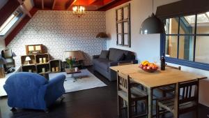 un soggiorno con divano blu e tavolo di Lant van Beloften a Vlissingen