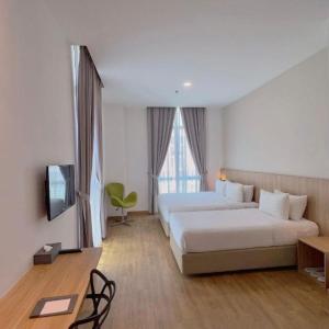 a hotel room with two beds and a television at S Hotel in Johor Bahru