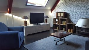 un soggiorno con TV, divano e tavolo di Lant van Beloften a Vlissingen