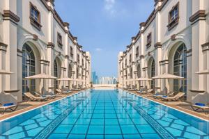 أوكس بوابة ابن بطوطة دبي في دبي: مسبح وسط مبنى مع كراسي