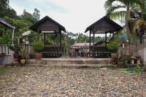 una casa con dos cenadores en un patio en OYO 89928 ACF Guest House, en Sungai Lembing