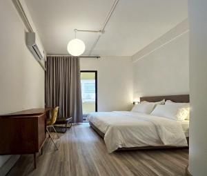 ein Hotelzimmer mit einem Bett und einem Schreibtisch in der Unterkunft Brown H in Pom Prap