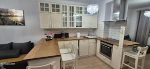 a kitchen with white cabinets and a wooden counter top at Apartament SORENTO 25 in Gorzów Wielkopolski