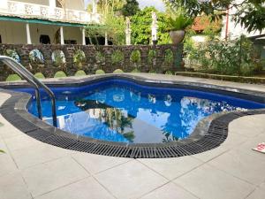 a pool with a reflection of the sky in the water at New Verona Hotel in Wennappuwa