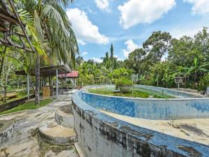 OYO 90636 Teratak Zakiah Chalet في Kampong Tanjong Belanja: مسبح في حديقة فيها أشجار في الخلفية