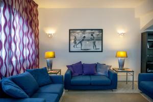 ein Wohnzimmer mit zwei blauen Sofas und lila Kissen in der Unterkunft Hotel Cutimare - Aeolian Charme in Acquacalda + 70 Fotos