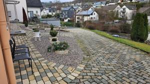 een stenen loopbrug met een bank en potplanten bij Apartment Wildgrund in Siegen